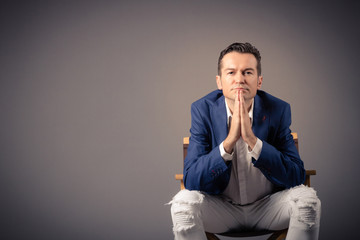 Portrait of pensive businessman sitting against the wall.