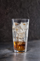 Glass of coke with ice on a dark background. Carbonated beverages. Selective fokus.
