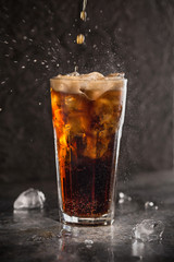 Glass of coke with ice on a dark background. Carbonated beverages. Selective fokus.