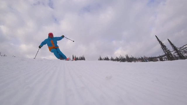 skier makes a turn on the slope, after the snowcat. the corduroy pattern on the snow slope. carving on mountain skiing. close-up of the skier. the sky at dawn with clouds. stock video footage