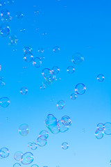 Many soap bubbles in air, blue sky, outdoor fun for everybody