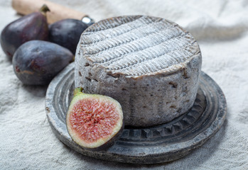 Whole round mature French Tomme cheese close up