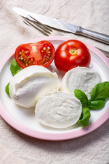 Soft white Italian cheese Mozzarella buffalo served with fresh tomato and green basil leaves