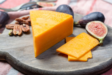Piece of hard orange Cheddar cheese close up