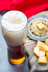Delicious mix, dark Belgian beer and pieces of hard cheese with mustard