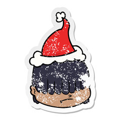 distressed sticker cartoon of a face with hair over eyes wearing santa hat