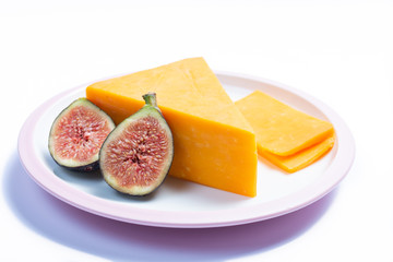 Fototapeta na wymiar Piece of hard orange Cheddar cheese on white board isolated close up