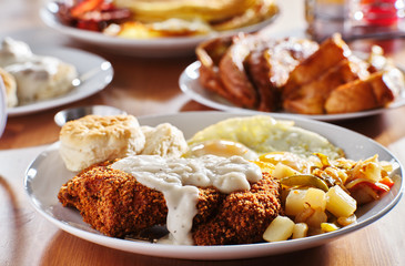 country fried steak with sunny side up eggs and biscuits