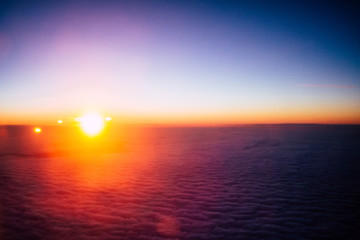 Obraz premium Sunrise above clouds from airplane