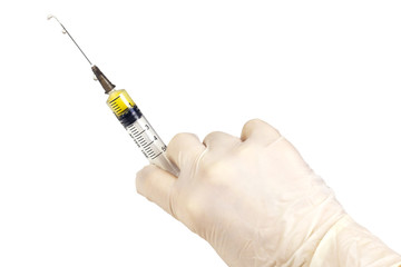 	The hand with medical glove is holding a 5ml syringe, which is filled with yellow liquid. Isolated...
