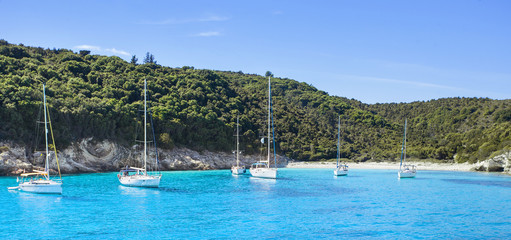 Fototapeta na wymiar Vacations in Greece. Beautiful bay with sailing boats yachts near the Antipaxos island. Panoramic view