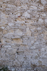 Old beige stone wall background texture close up