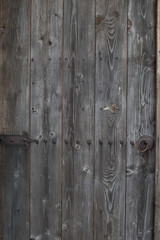 Old gray threadbare wooden door in an old house