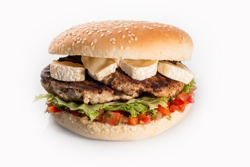 cheeseburger with beef cutlet, bacon, tomatoes and cheese slices, seasoned with sauce and green salad for a restaurant menu on a white isolated background