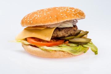 cheeseburger with beef cutlet, bacon, tomatoes and cheese slices, seasoned with sauce and green salad for a restaurant menu on a white isolated background