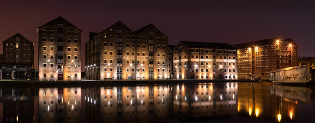 Fototapeta na wymiar Gloucester Docks at night time with reflections of warehouse