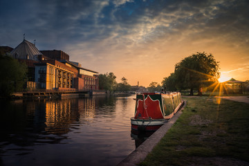 Stratford upon Avon river with Theatre and Narrowboat at sunrise - obrazy, fototapety, plakaty
