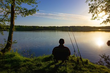 Angler sitting on the chair during sunny morning