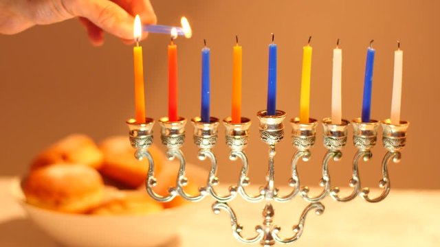 Lighting full 8 days Hanukkah Candles, Jewish Holiday. Hanukkah Candles Are Burning On Light Background with baked sugar Doughnut with jam