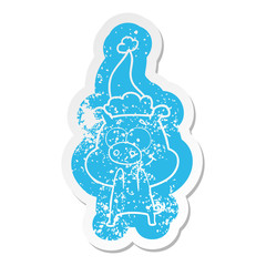 happy cartoon distressed sticker of a pig wearing santa hat