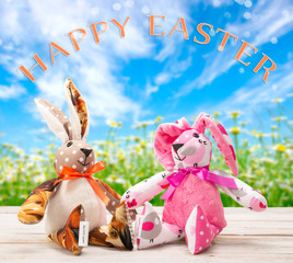 Two Easter bunnies with happy easter inscription. Easter holiday concept.
