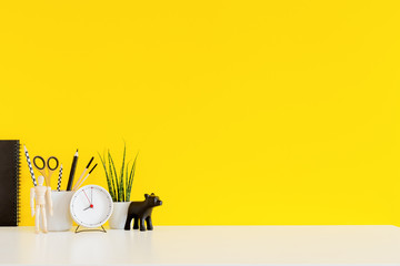 Creative desk with yellow wall. Mock up.