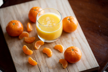 A glass of orange juice with clementines