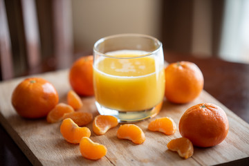 A glass of orange juice with clementines