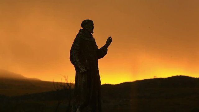 A Catholic statue shot with an orange sunset, near the Sao Francisco River, Minas Gerais, Brazil.