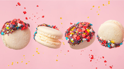 Colorful macarons cookies in motion. French cakes. Sweet and colorful French macaroons fall or fly...