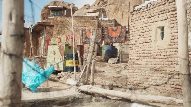 Barbed wire fence near houses in Kandovan, Iran. Beautiful Carpets in the back.