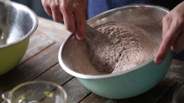 Close up footage of a chef mixing ingredients together for cake batter to back a stunning cake.