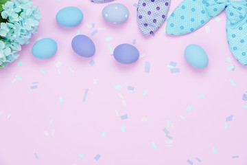 Table top view shot of decorations Happy Easter holiday background concept.Flat lay  eggs with cute bunny ear & confetti on modern rustic pink paper.Blank space creative design for mock up & template.