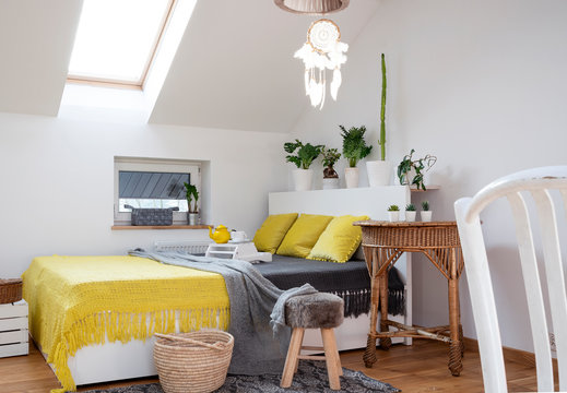 White Interior Of Bedroom With Yellow Bedspread And Pillows