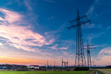 Stromtrasse mit Umspannwerk im Sonnenuntergang