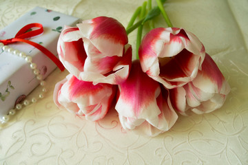 bouquet of pink and white tulips and gift boxes