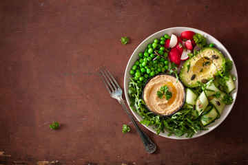 healthy vegan lunch bowl with avocaco cucumber hummus peas radish