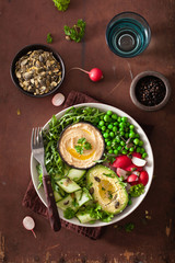 healthy vegan lunch bowl with avocaco cucumber hummus peas radish