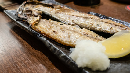 Fish served while grilling on dish at Japanese izakaya restaurant