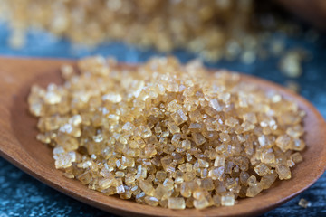Close up of sugar on wooden spoon.