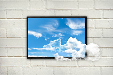 Frame with clouds and blue sky on a white brick wall, thinking outside the box concept