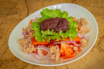 Salad with tomatoes, red onion, tuna, olive paste and fresh salad leaf.