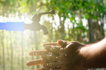 Hand washing on blur green nature background, Water energy conservative concept, Clean hand by...