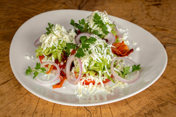 Salad with tomatoes, grated cucumbers, onion, garlic, roasted red pepper, white cow cheese and parsley.
