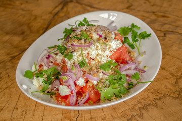 Salad with peeled tomatoes cut into cubes, cow cheese, walnuts, red onion and fresh green spices.