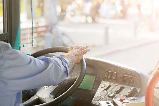 Hands of driver in a modern bus by driving.Concept - close-up of bus driver steering wheel and driving passenger bus. Toning
