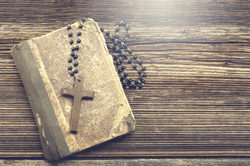 Very old holy bible and wooden cross