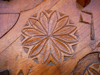 Detailed hand carved flower on traditional hungarian oak wood gate pylon .