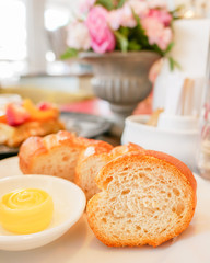 Closeup of baked bread and butter on white plate (soft focus)