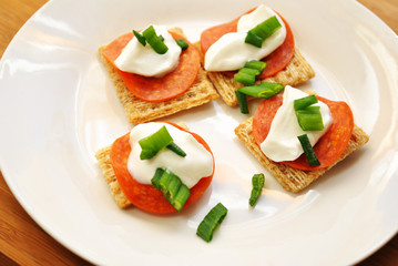 Appetizer of Wheat Crackers, Pepperoni, Sour Cream & Sliced Scallions